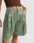 Person wearing green shorts on a plain background