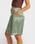 Person wearing a green skirt on a plain background