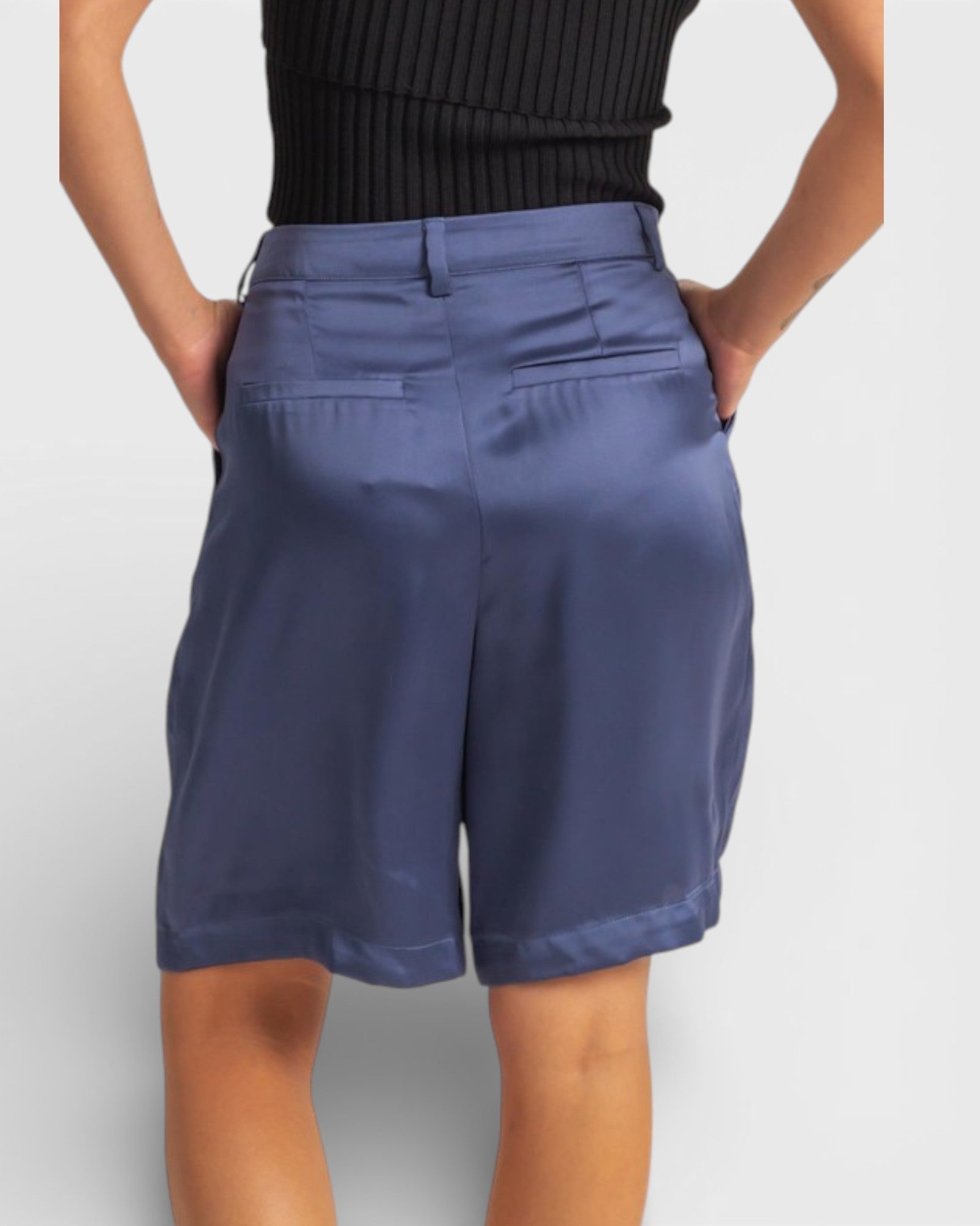 Person wearing blue shorts on a plain background