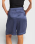 Person wearing blue shorts on a plain background