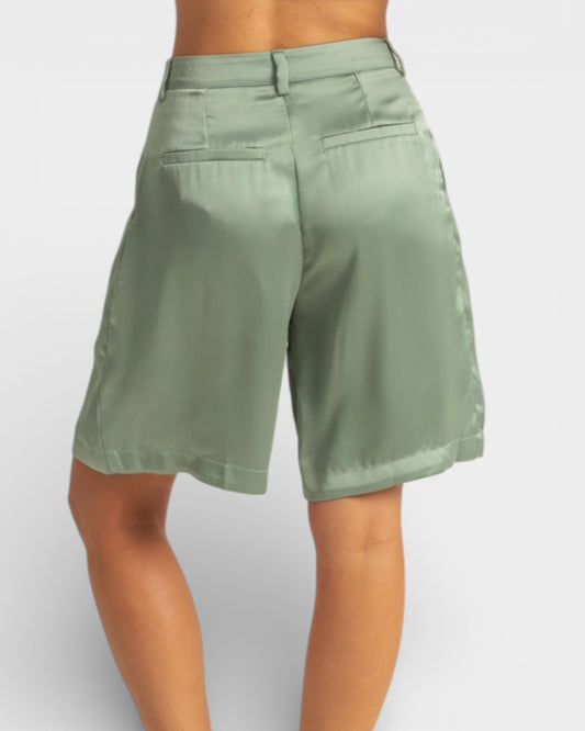 Green shorts worn by a person on a white background