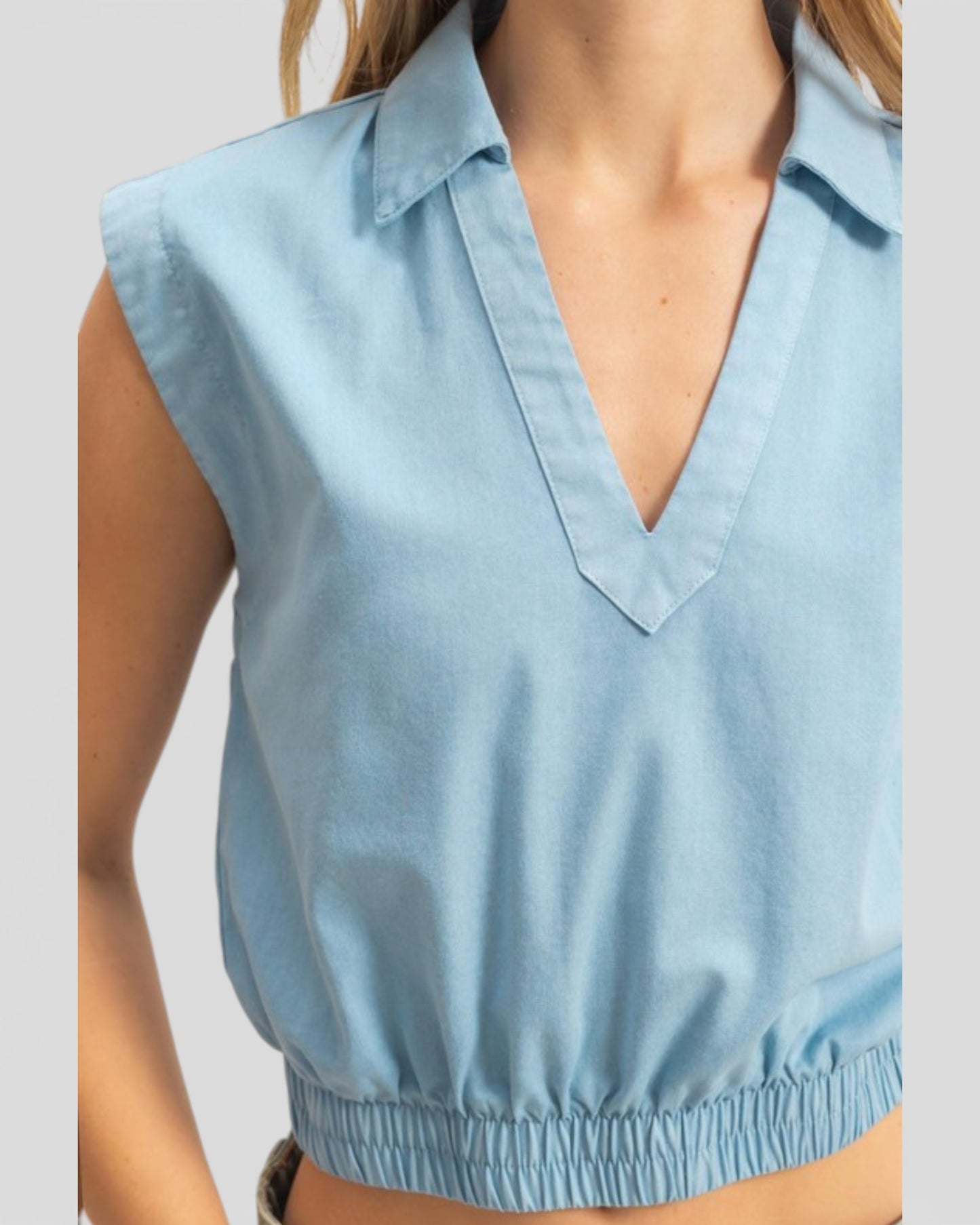 Light blue sleeveless top worn by a person on a plain background