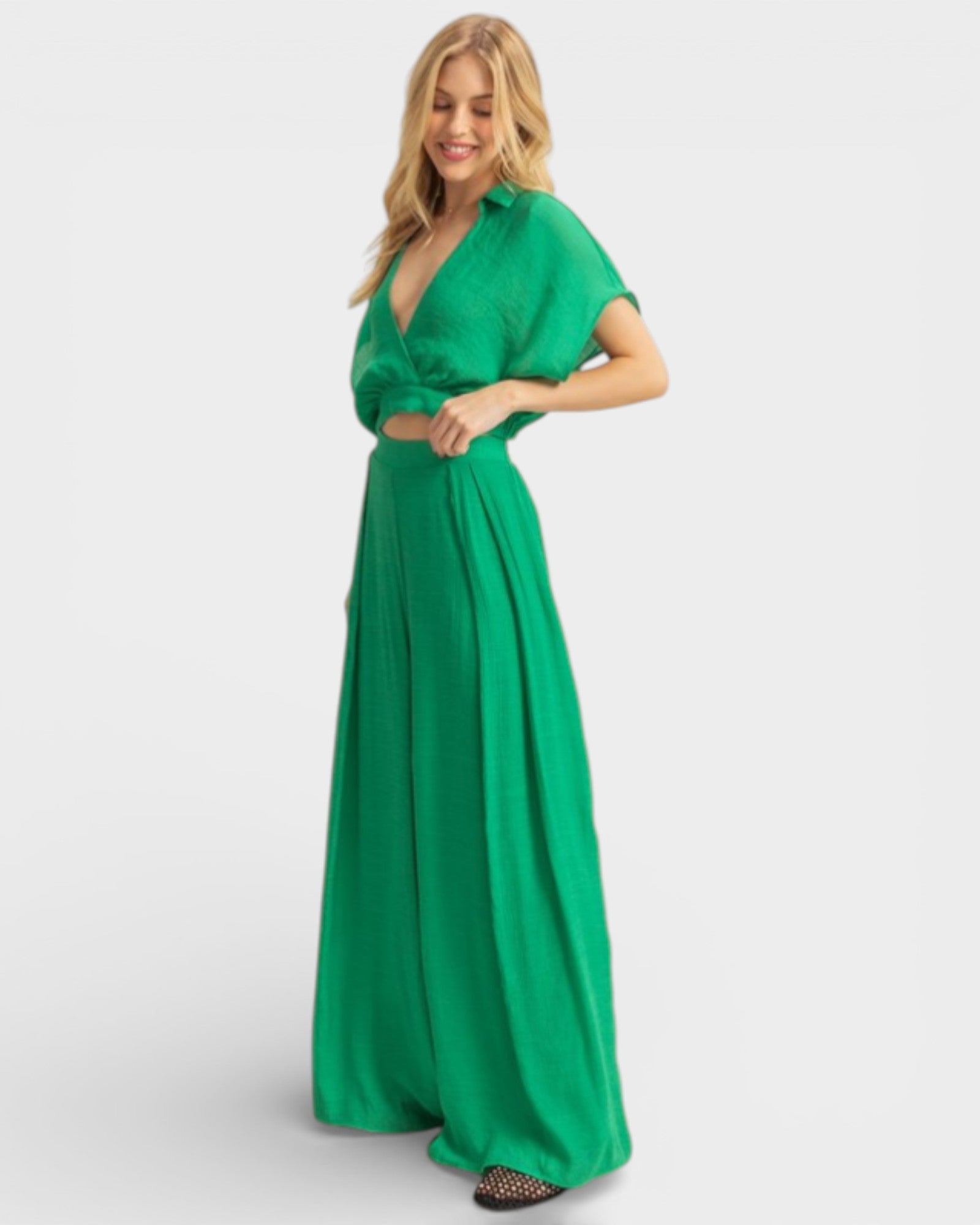 Woman wearing a green satin outfit on a white background
