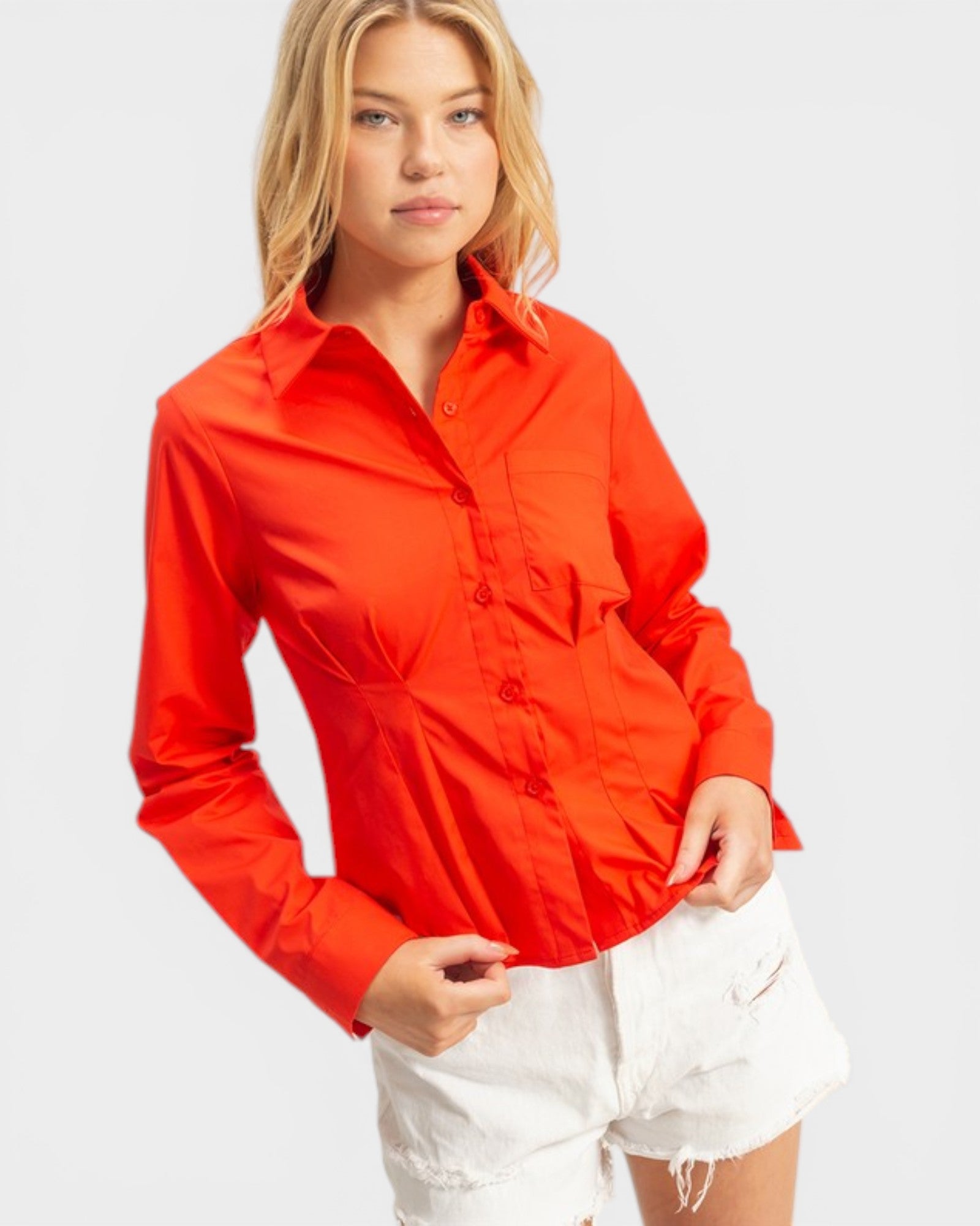 Woman wearing a red shirt and white shorts on a plain background