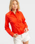 Woman wearing a red shirt and white shorts on a plain background