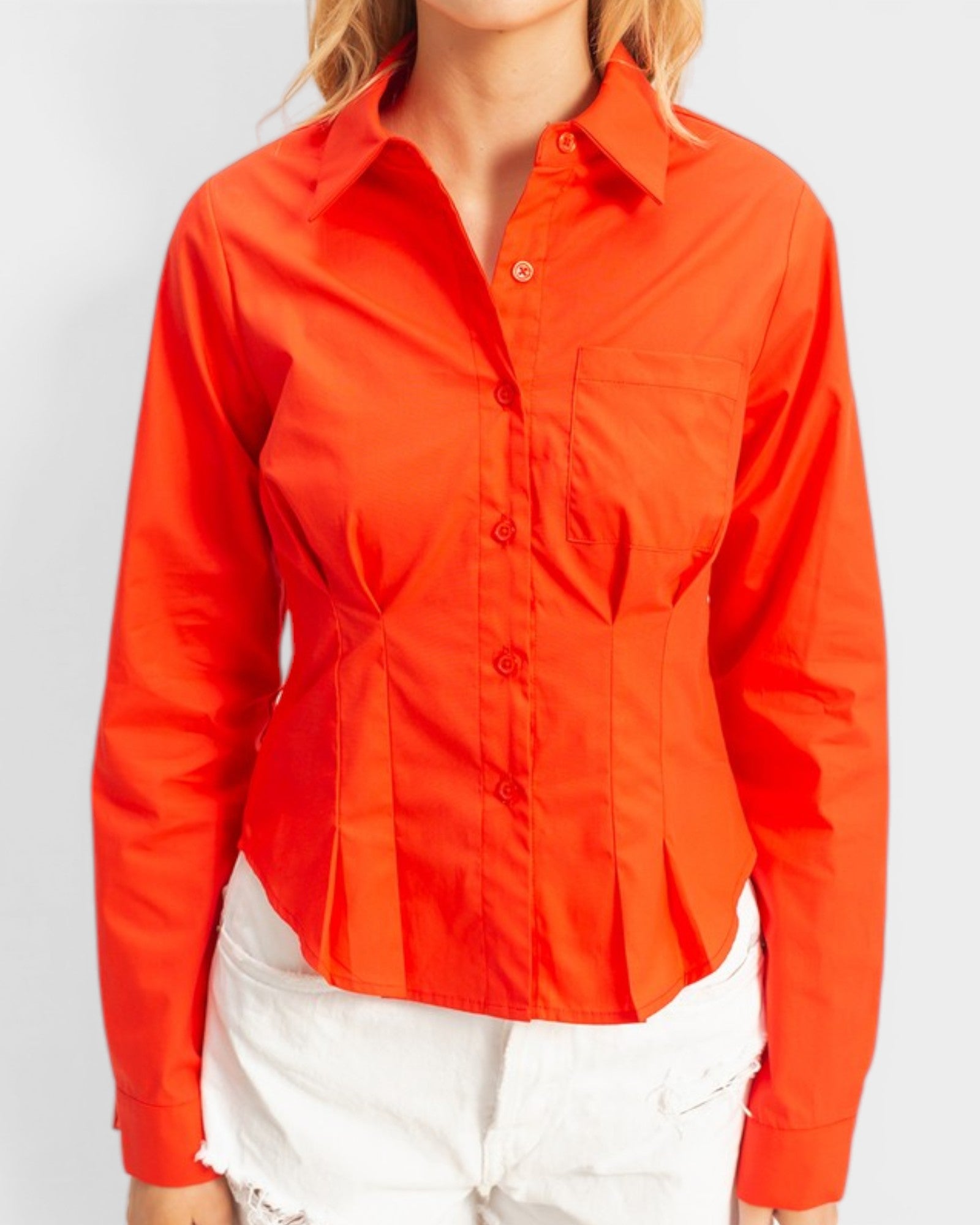 Person wearing a bright orange button-up shirt on a plain background