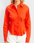 Person wearing a bright orange button-up shirt on a plain background