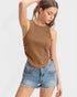 Woman wearing a brown tank top and denim shorts on a white background