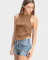 Woman wearing a brown sleeveless top and denim shorts on a white background