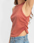 Person wearing a rust-colored tank top with a white background