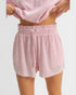 Person wearing pink striped shorts and a matching top on a light gray background