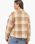A woman shown from the back wearing a fuzzy cropped plaid jacket in beige and brown tones, paired with blue jeans, against a plain white studio background.