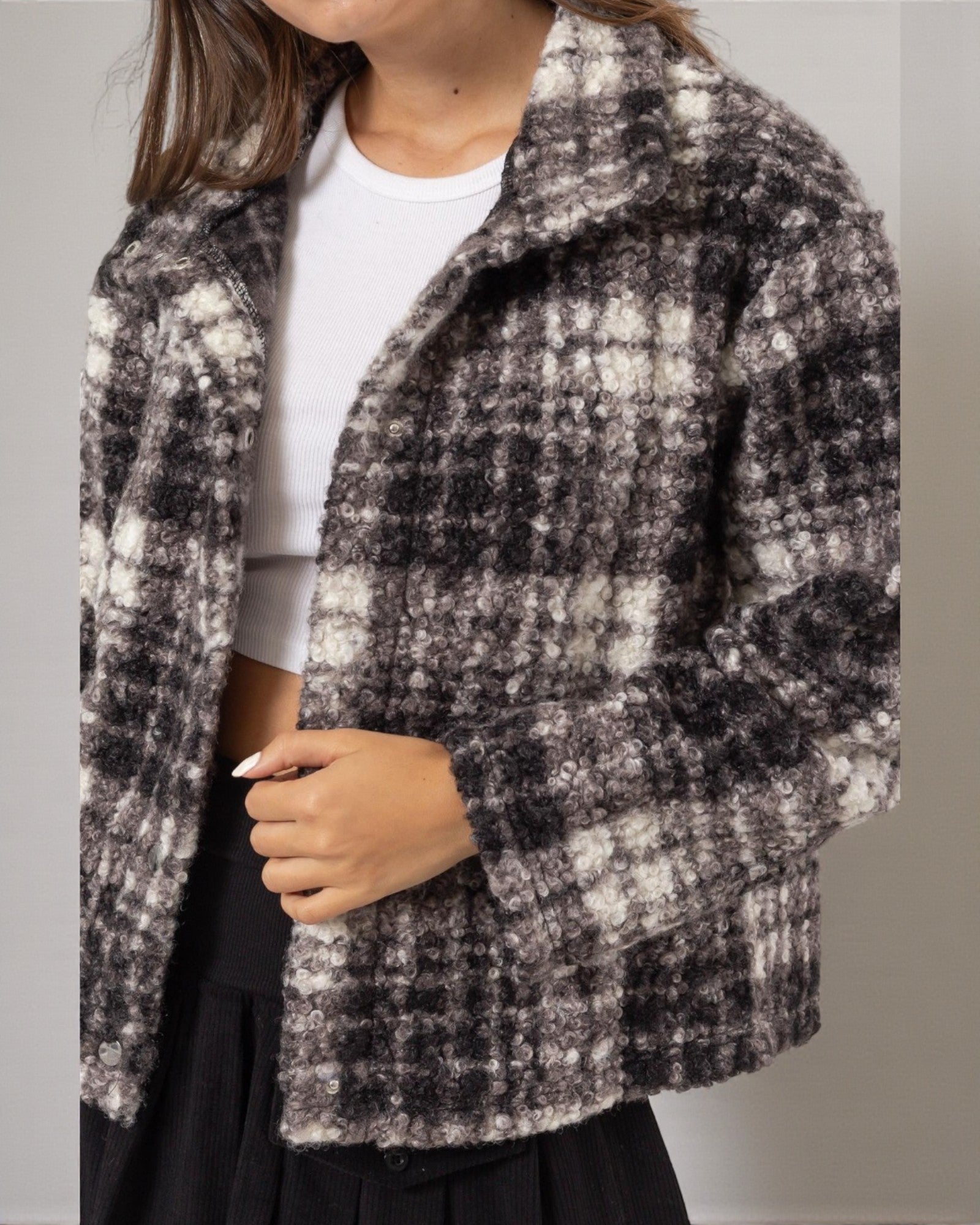 Person wearing a checkered coat with a neutral background