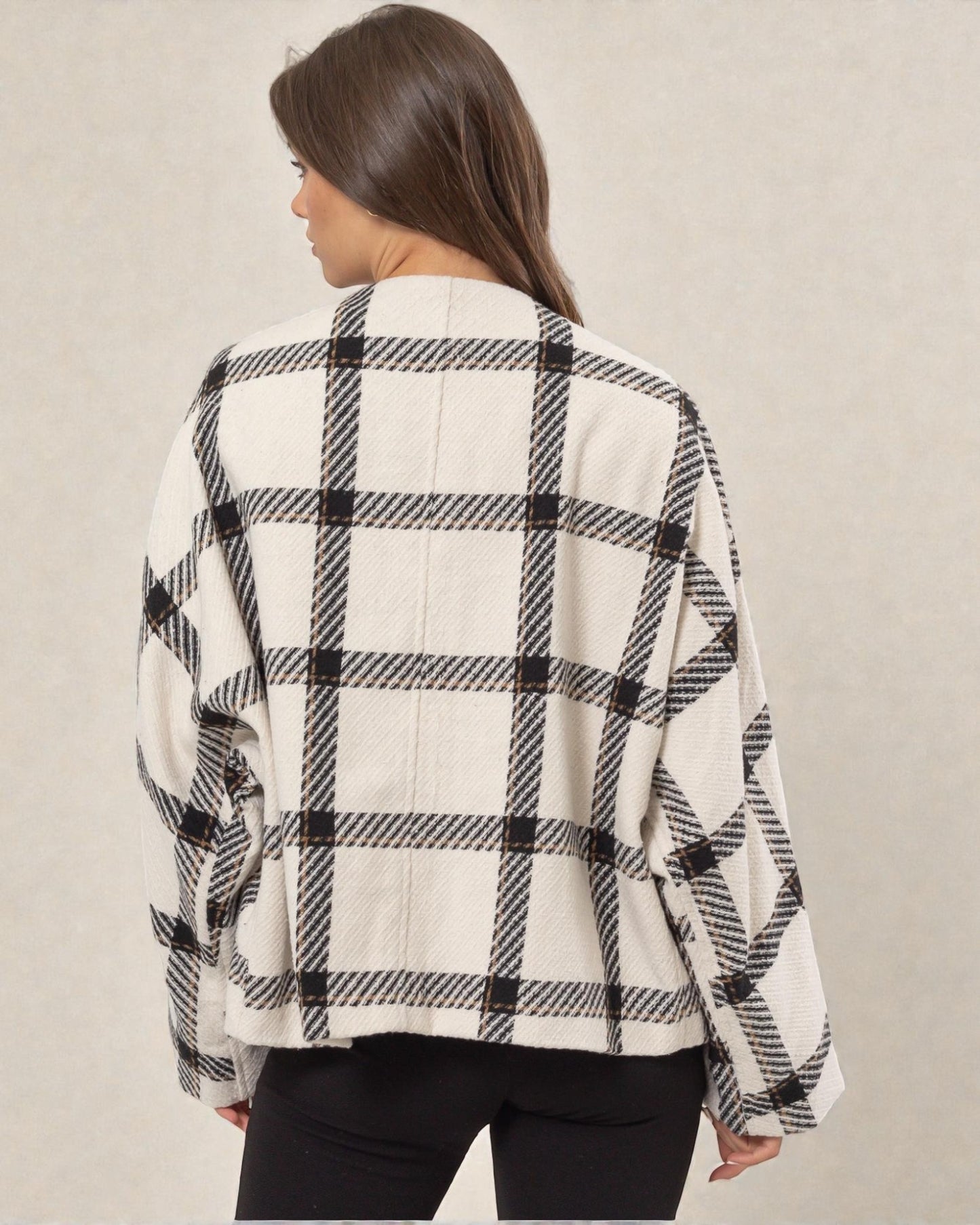 Person wearing a black and white checkered shirt against a plain background