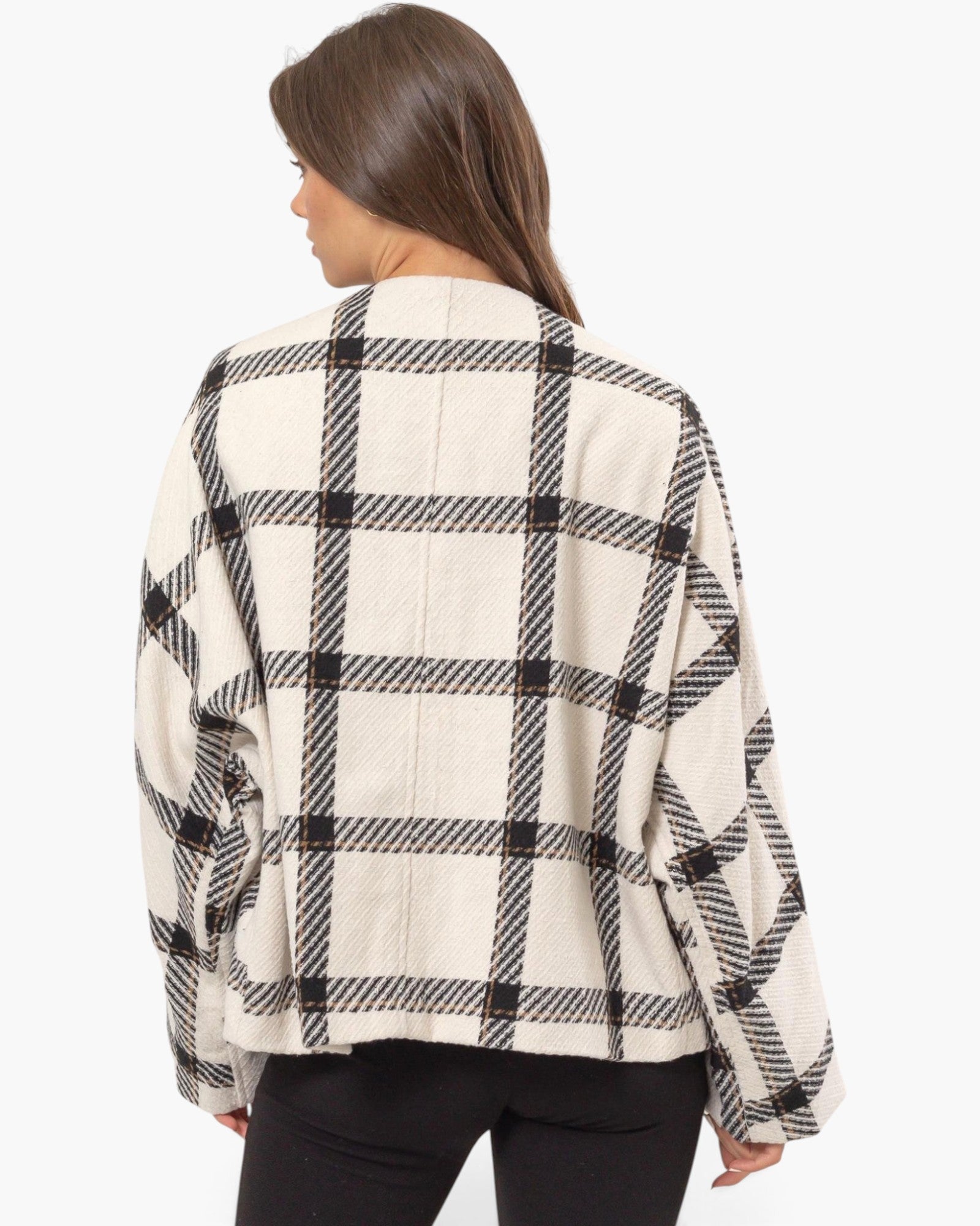 A woman shown from the back wearing a cream-colored cropped jacket with a black and gray plaid pattern, paired with black pants, against a plain white background.