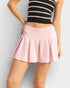 Person wearing a black and white striped top with a pink skirt on a light gray background