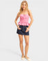 Woman wearing a pink peplum top and denim skirt on a white background