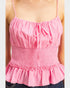 Pink ruffled top worn by a person on a plain background