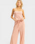 Woman wearing a pink ribbed jumpsuit on a white background