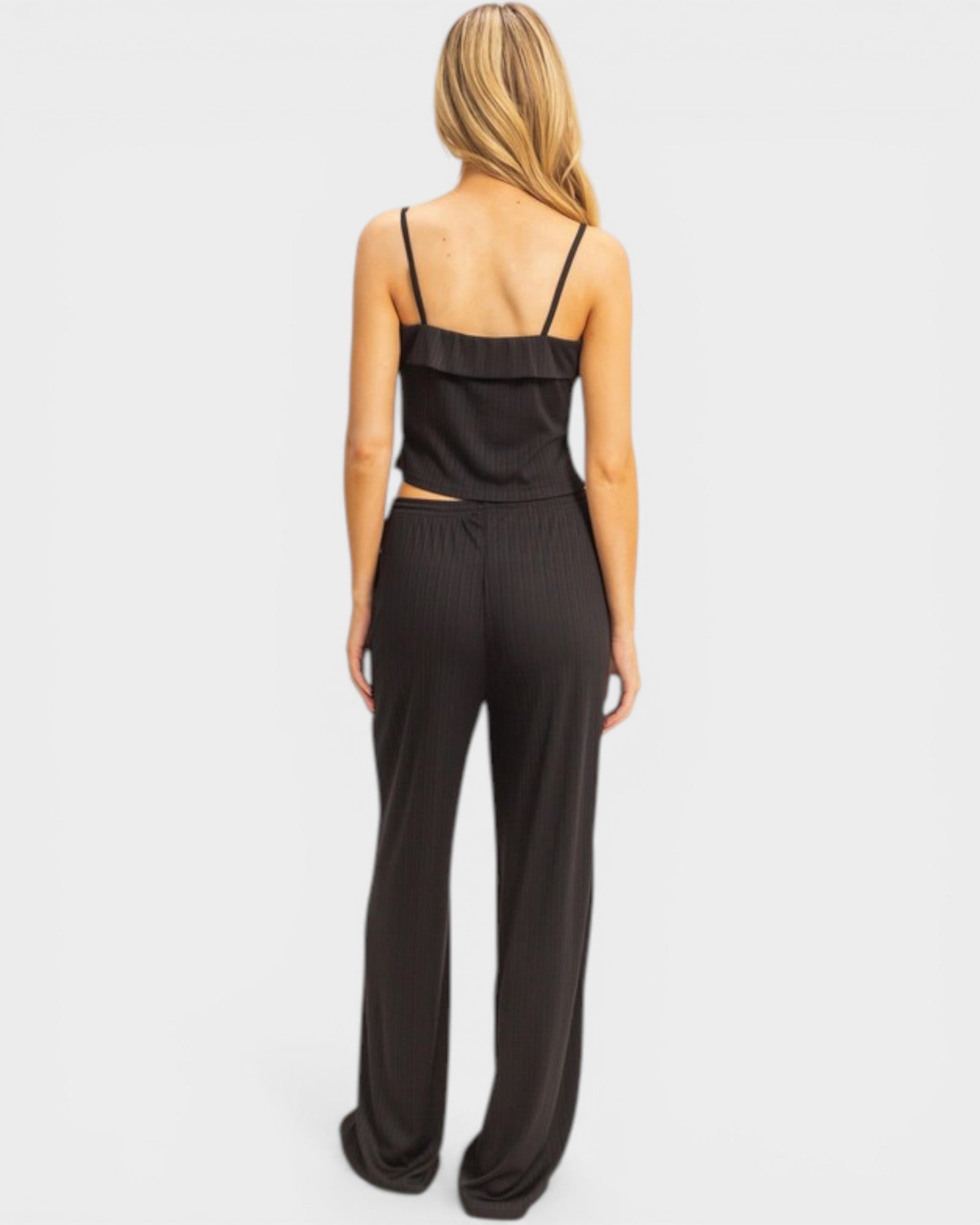 Black satin jumpsuit worn by a model on a white background