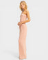 Woman wearing a long, light pink dress against a white background