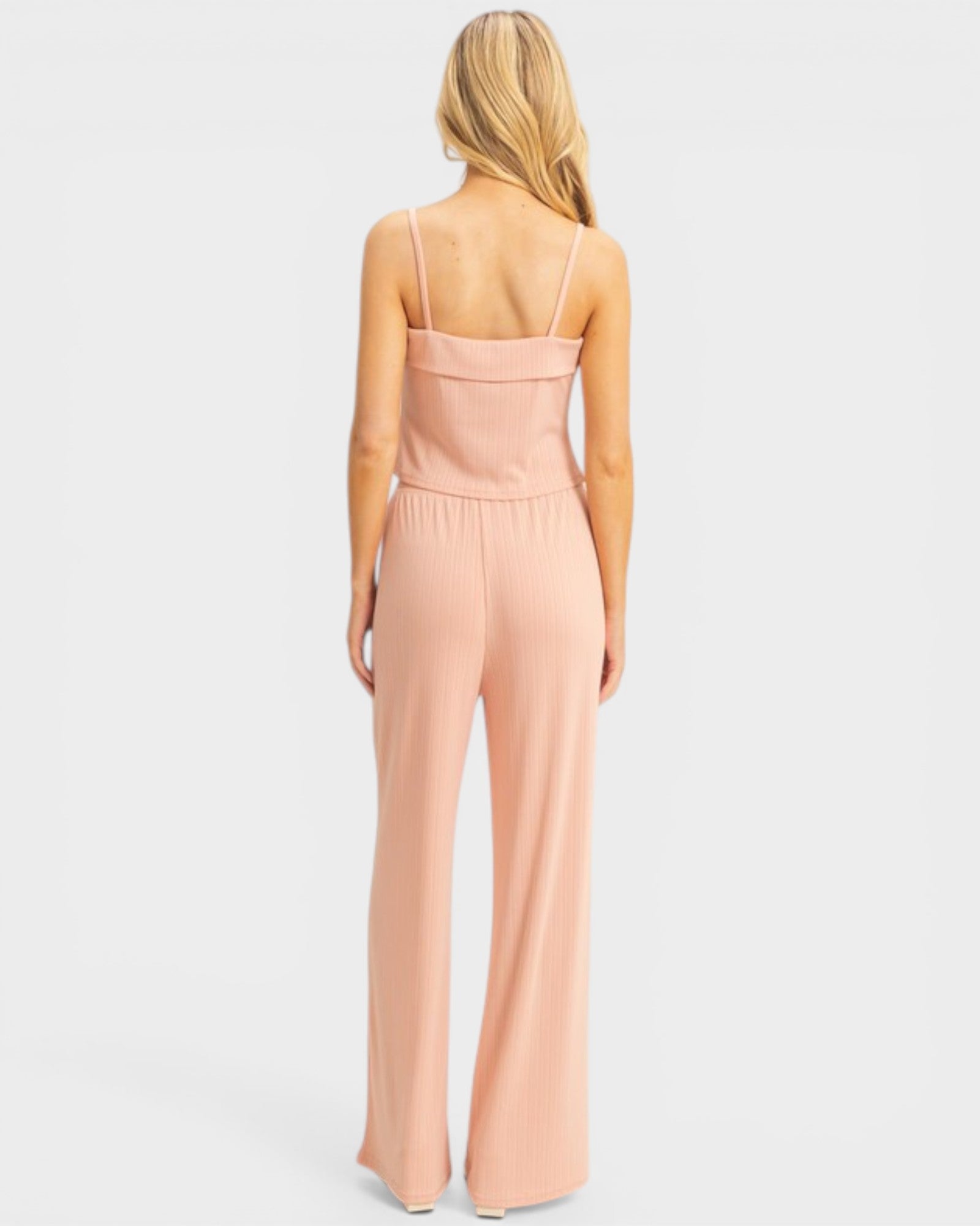 Woman wearing a pink jumpsuit on a white background