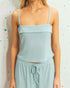 Light blue ribbed top and skirt set against a polka dot background