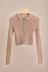 Beige ribbed zip-up sweater on a beige background