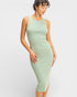 Woman wearing a light green ribbed dress on a white background