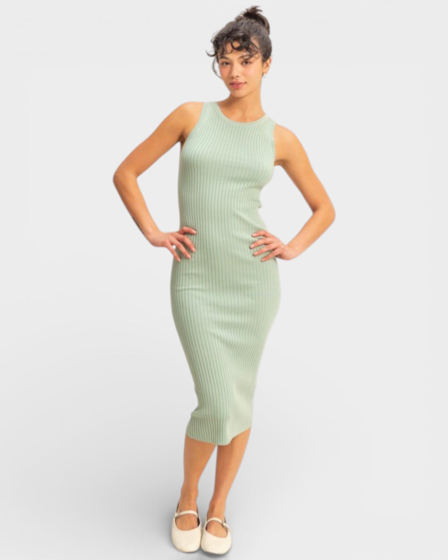Woman wearing a light green ribbed dress on a white background