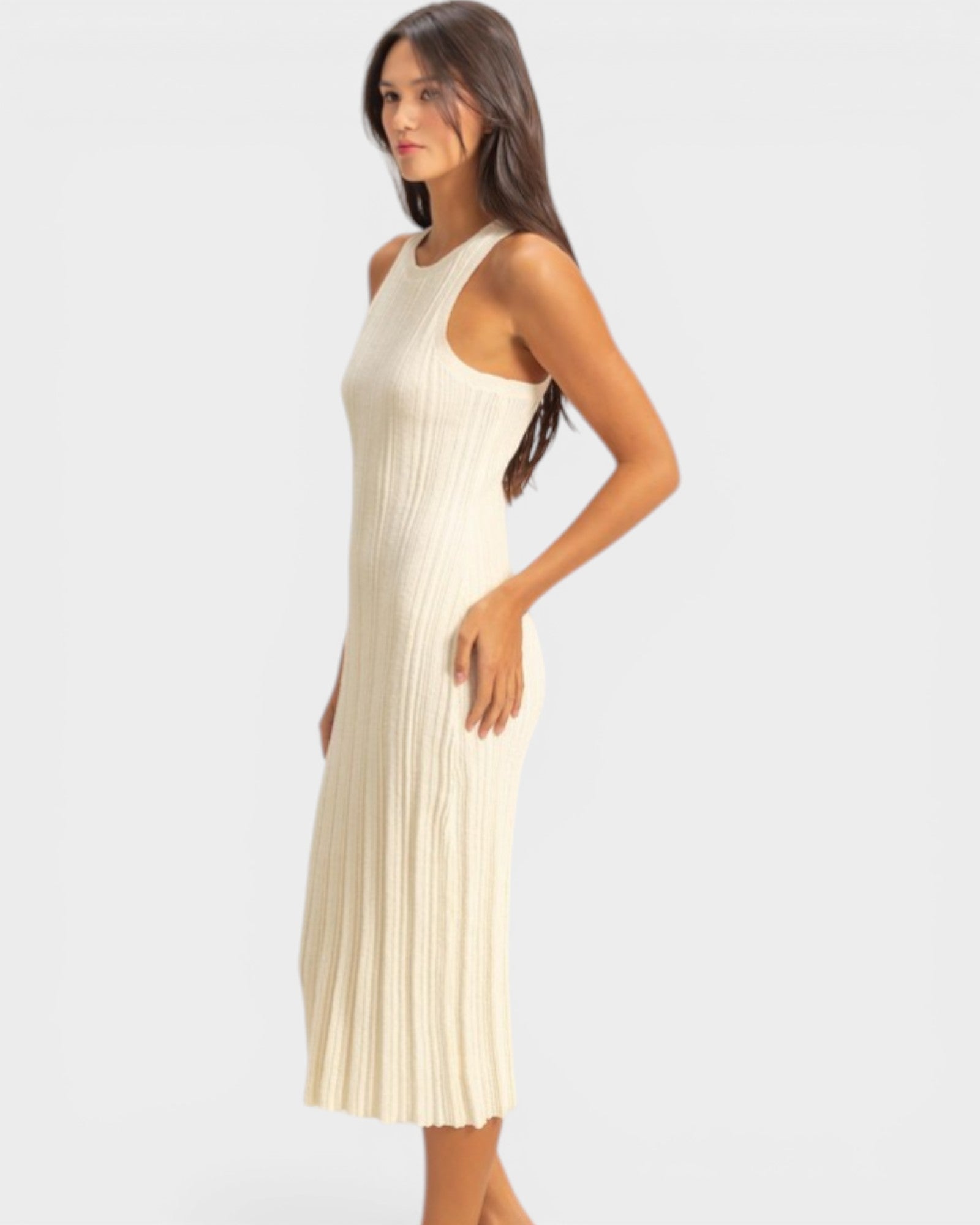 Woman wearing a white ribbed dress on a light gray background