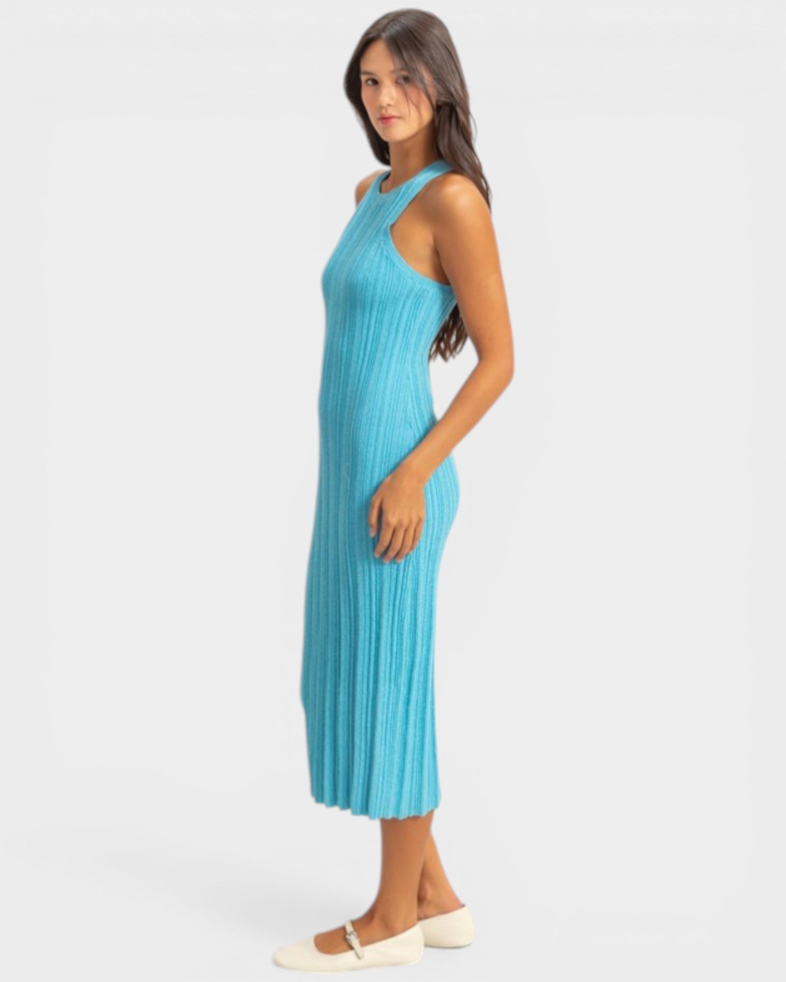 Woman wearing a blue ribbed dress on a white background