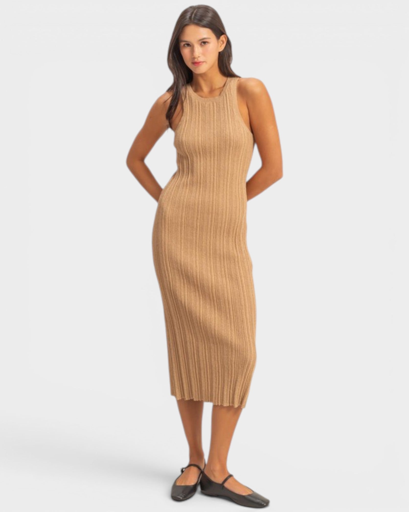 Woman wearing a beige ribbed dress on a white background