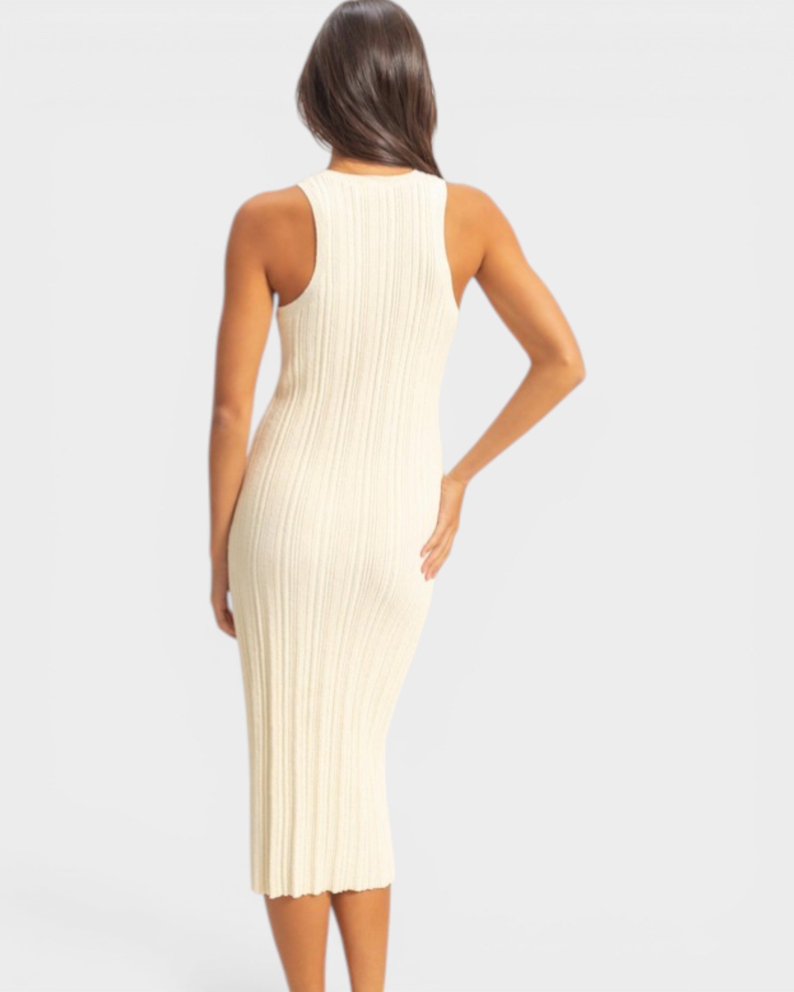 Woman wearing a beige ribbed dress on a light gray background