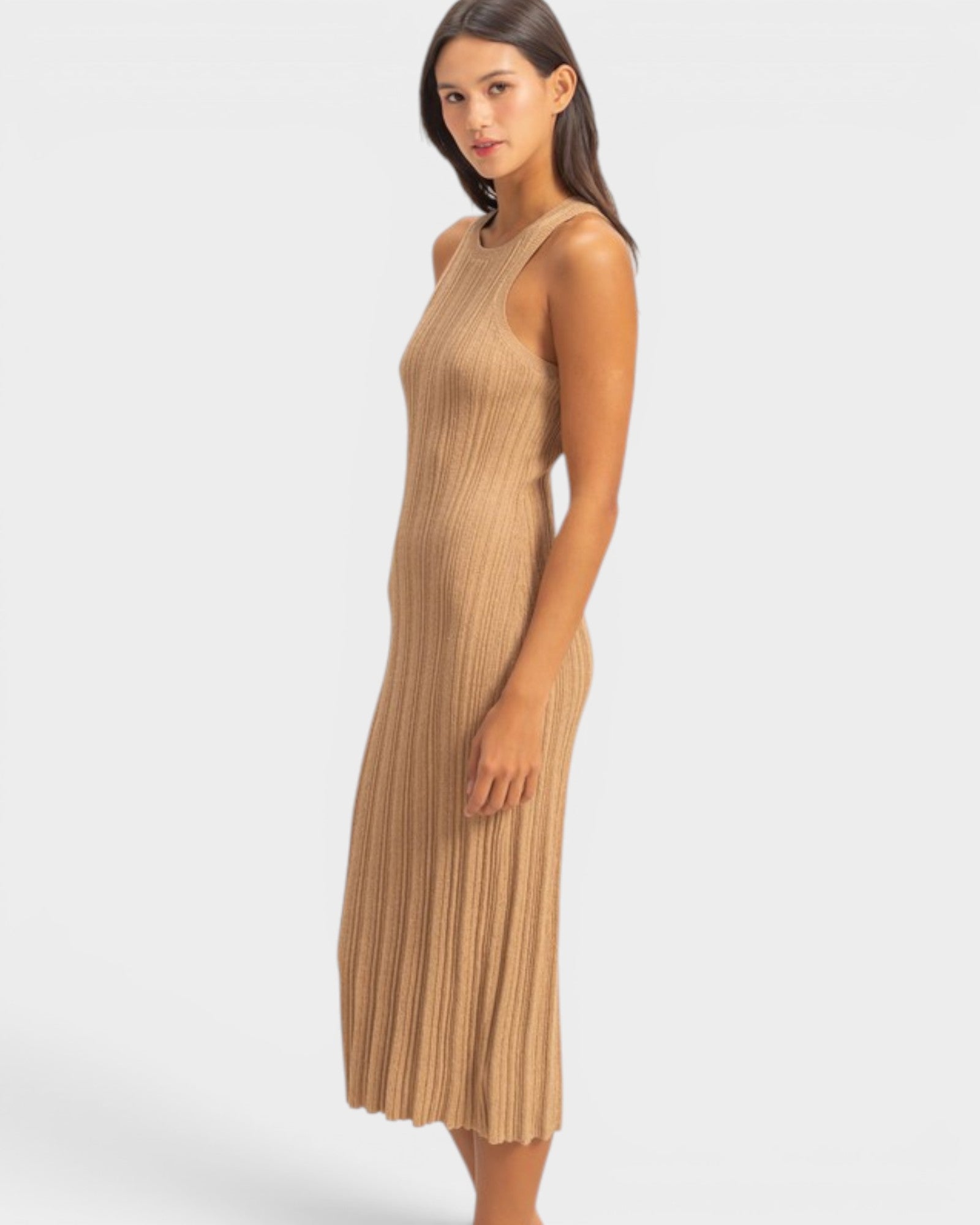 Woman wearing a beige pleated dress on a white background