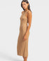Woman wearing a beige pleated dress on a white background