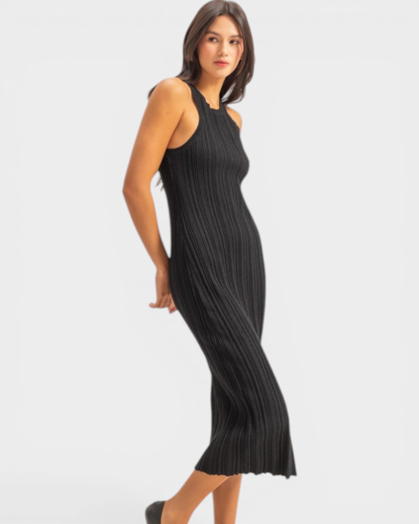 Woman wearing a black pleated dress on a white background