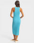 Woman wearing a turquoise ribbed dress on a white background