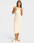 Woman wearing a cream ribbed dress against a white background