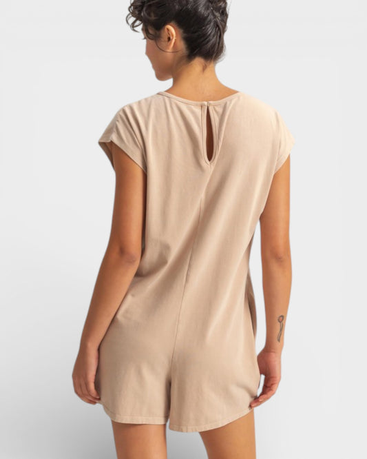Person wearing a beige dress against a white background