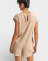 Person wearing a beige dress against a white background