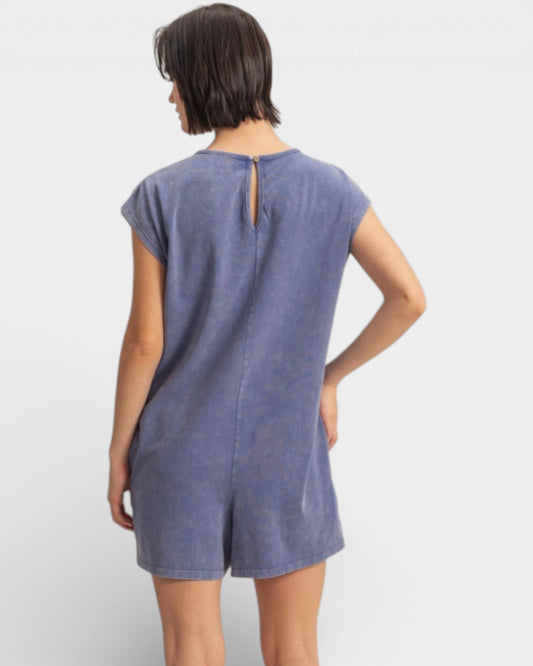 Woman wearing a blue dress with a cutout back detail on a white background