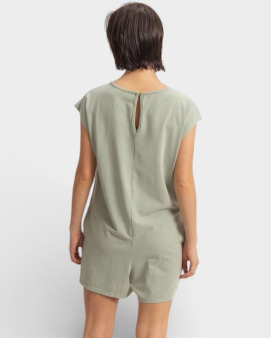 Person wearing a green romper on a white background