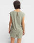 Person wearing a green romper on a white background