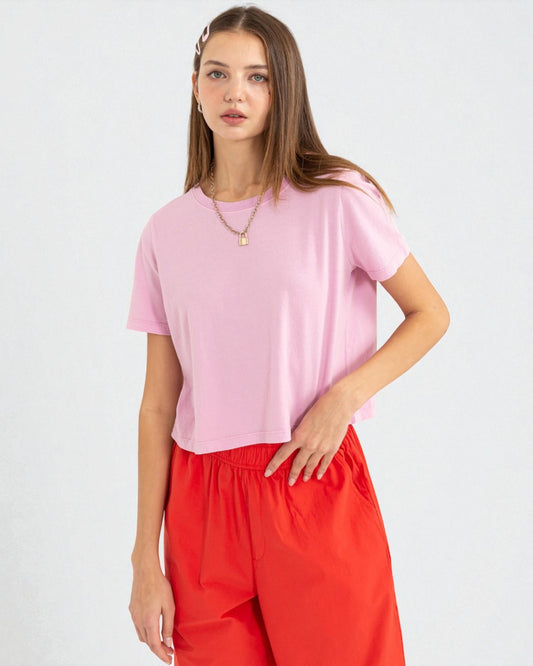Woman wearing a pink top and red pants on a white background
