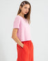 Woman wearing a pink top and red pants on a white background