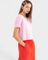 Woman wearing a pink top and red pants on a white background