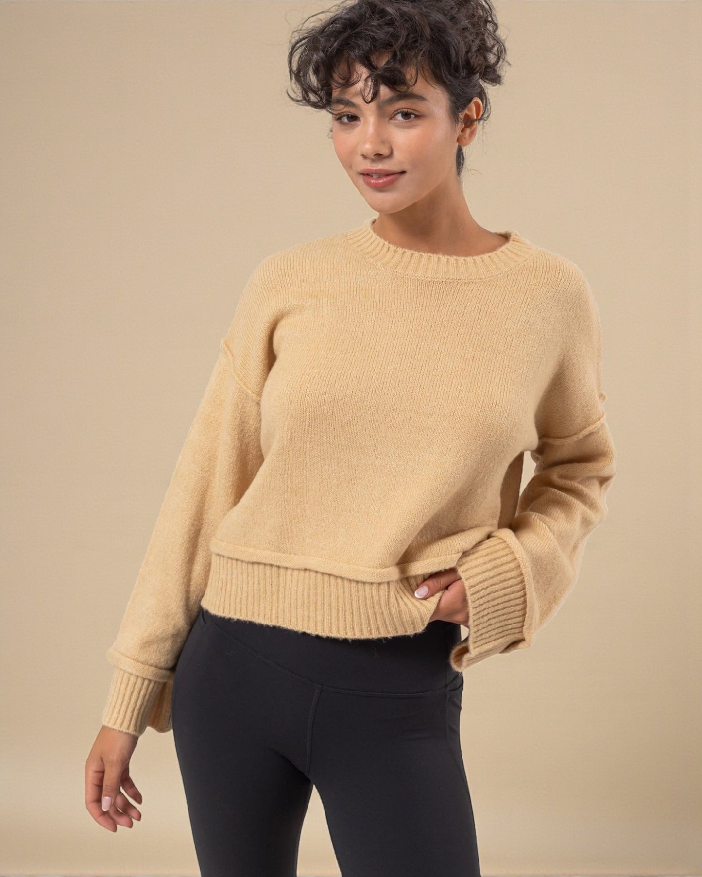 Woman wearing a beige sweater against a beige background