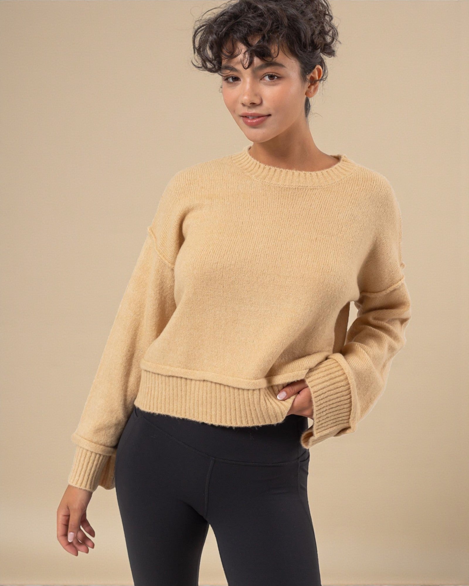 Woman wearing a beige sweater against a beige background