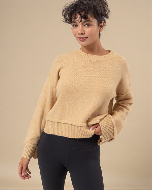 Woman wearing a beige sweater against a beige background